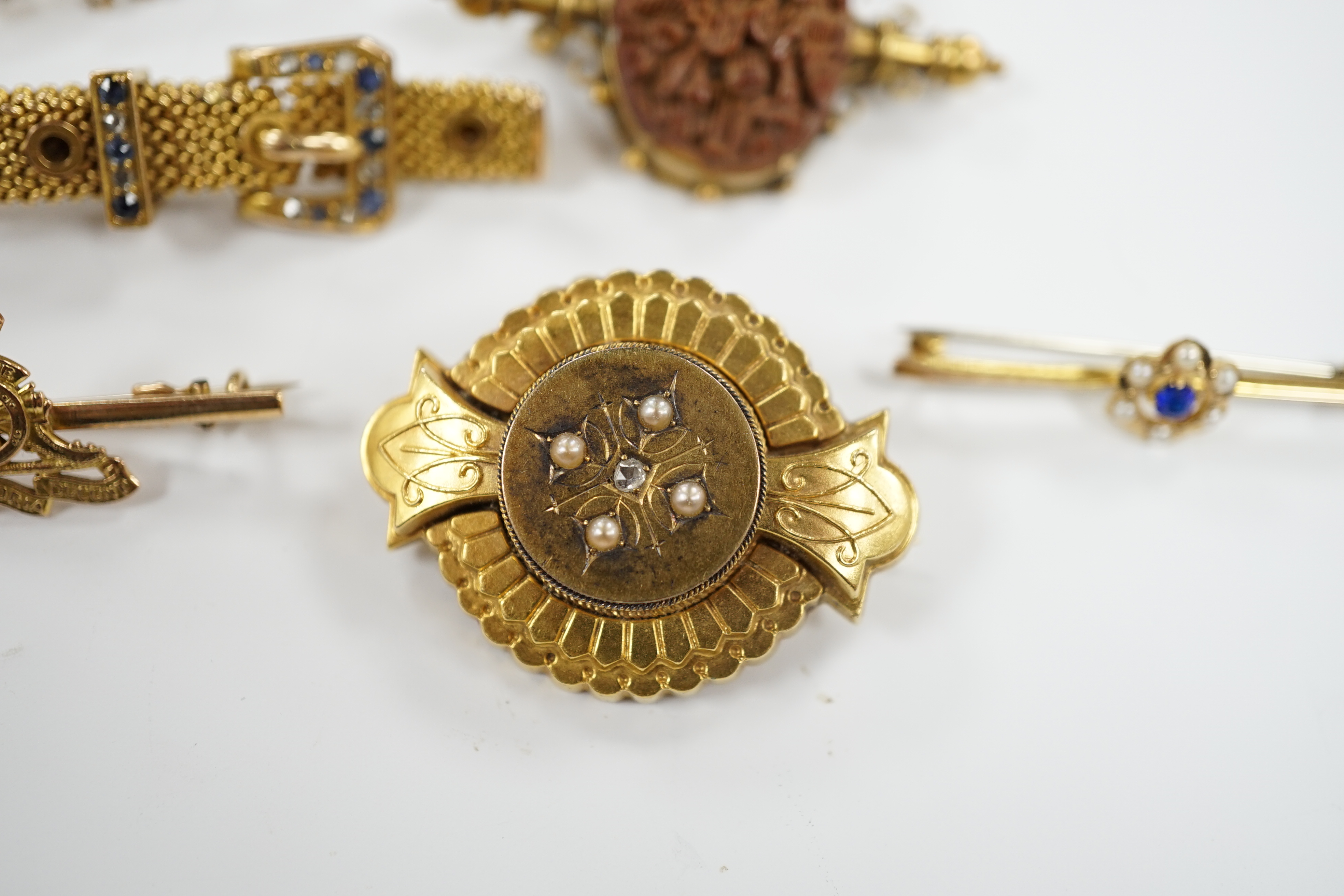 Four assorted yellow metal and gem set bar brooches including sapphire and diamond chip set buckle brooch, 51mm and two other yellow metal brooches, one set with diamond and split pearl